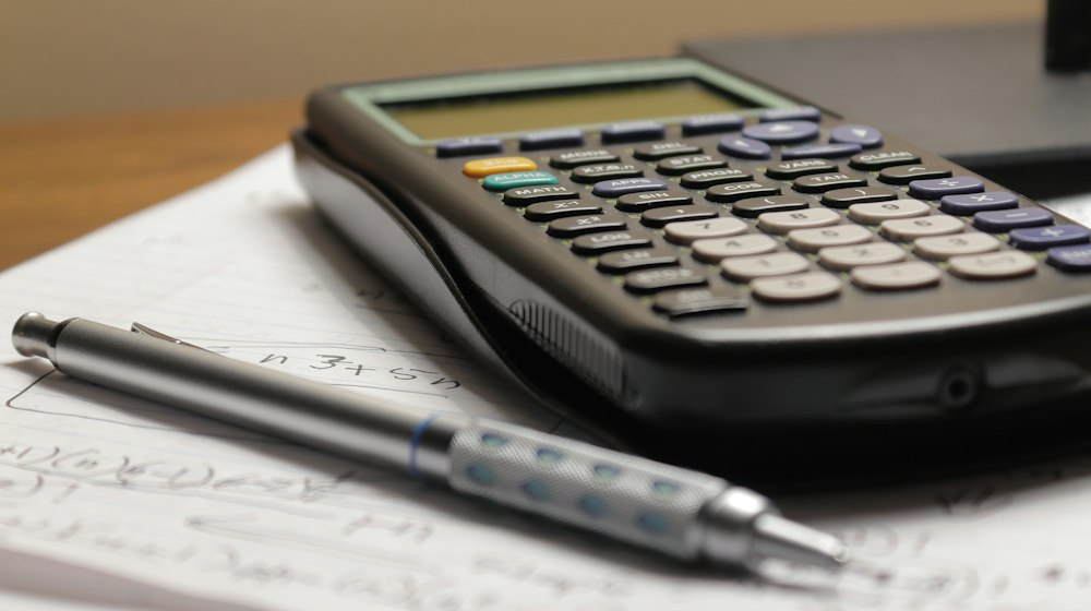 A calculator and pen on paper