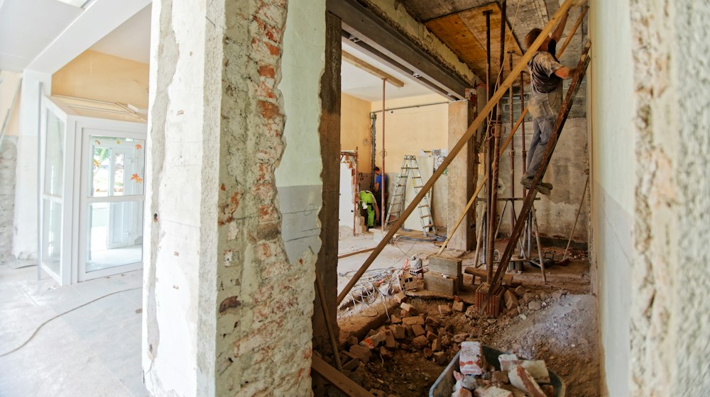 A person on a ladder working inside a room